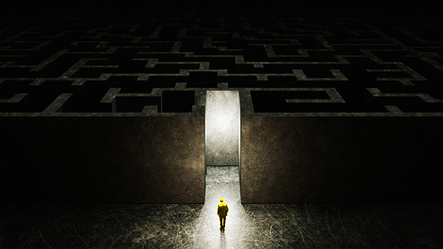 Mann vor Eingang zu einem dunklen Labyrinth